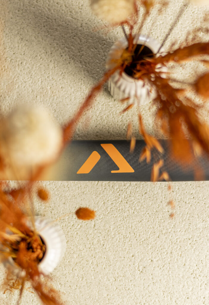 A-LIFE Ibiza Drop premium low bow hockey stick on beige textured background, minimalist design.