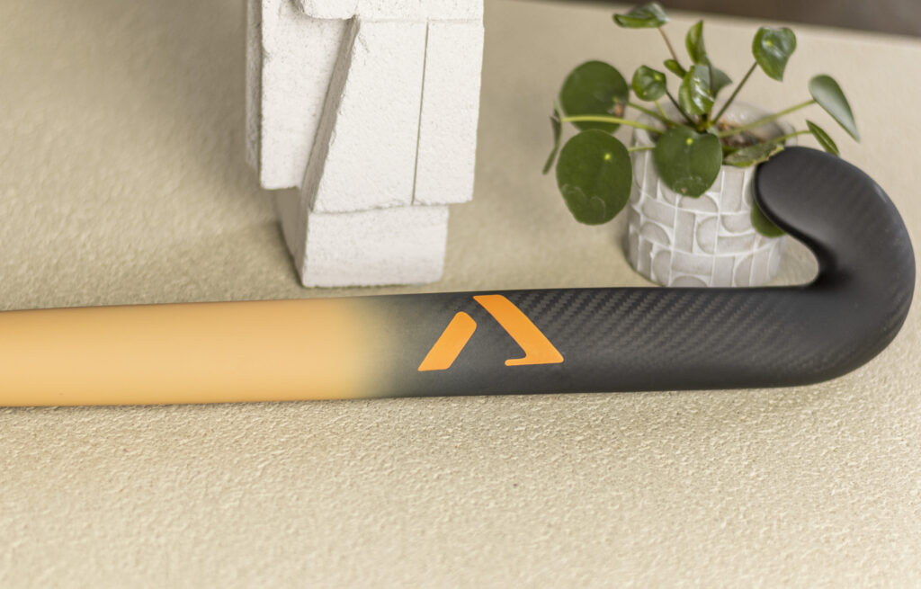 Detail view of A-LIFE hockey stick carbon texture and minimalist logo.